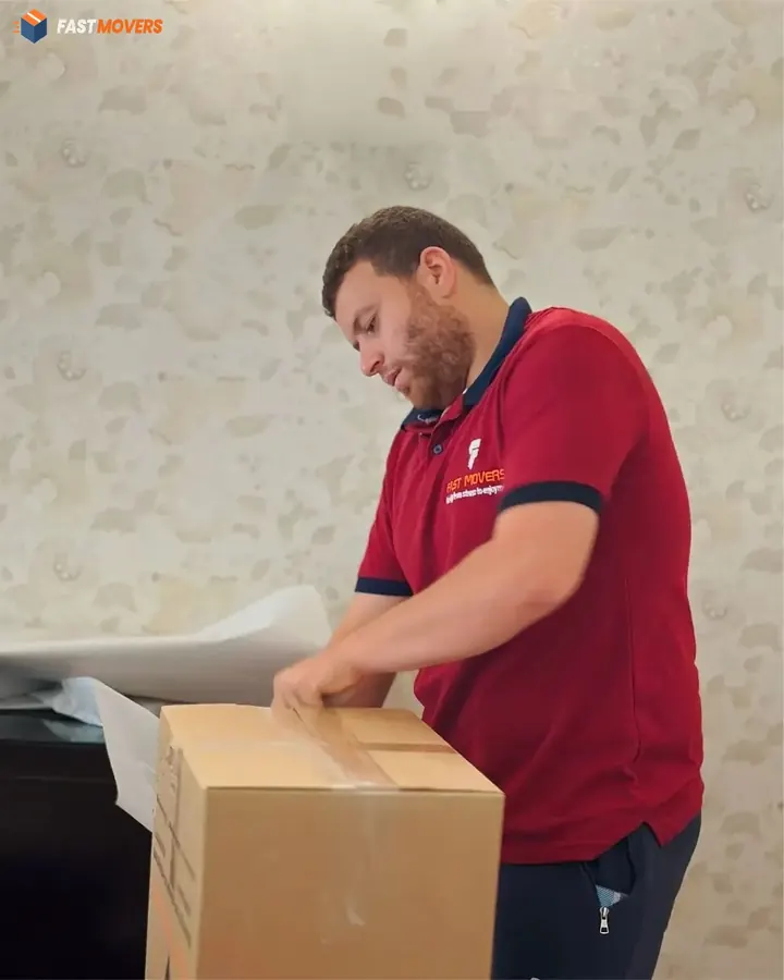فني يقفل كرتونة بالشريط اللاصق